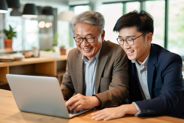 パソコンで老人ホームを探す親子